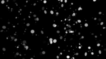 Freeze motion of white snow coming down, isolated on black background.