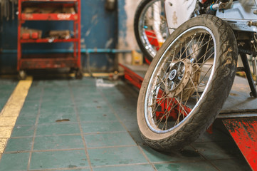 closeup rust on motorcycle wheel repair with soft-focus and over light in the background
