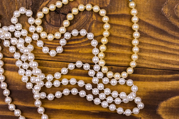Pearl necklace on wooden background. Top view