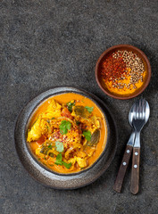 INDIAN FOOD. Traditional KERALA FISH CURRY with naan bread, gray plate, black background 