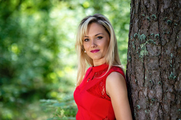 Fototapeta premium Beautiful, blonde woman portrait on a forest background.