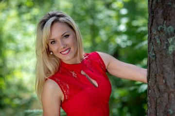 Fototapeta premium Beautiful, blonde woman portrait on a forest background. Copy space.
