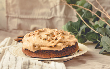 Cream Snickers Pie. Chocolate Sponge Cake filled with whipped cream and peanuts.. On white linen tablecloth background. Toning.