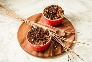Cherry crumble with chocolate granola served served in portioned red cups.