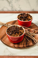 Cherry crumble with chocolate granola served served in portioned red cups.