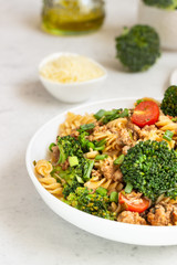 Pasta with meat sauce, cherry tomatoes and broccoli. Mediterranean cuisine with pasta ingredients - olive oil, broccoli and tomatoes.