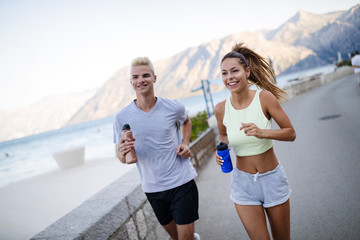 Happy fit people couple jogging and running outdoors