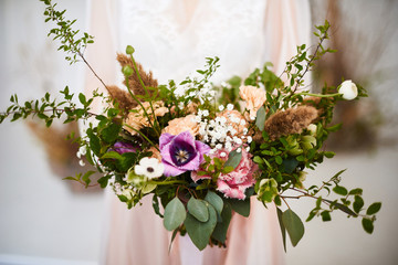 Very nice young woman holding big and beautiful colourful flower wedding bouquet