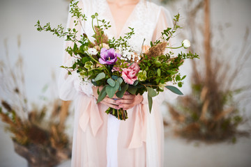 Delicate wedding bouquet in the hands of the bride