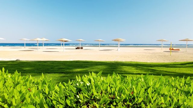 4k panning video of camera moving from bush fence and showing beautiful sandy sea beach