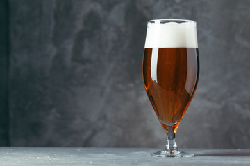 Single beer glass close up on dark stone background
