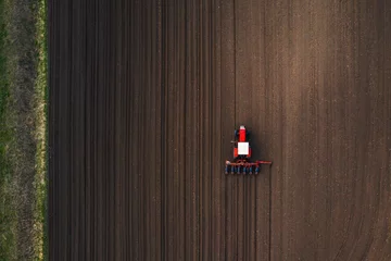 Fotobehang Tractor Bovenaanzicht van tractor die maïszaad in het veld plant