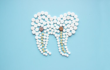 Tooth made of pills. Dental clinic concept.
