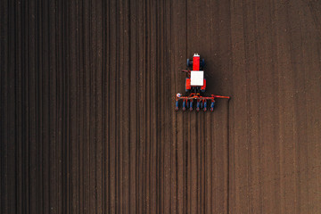 Top view of tractor planting corn seed in field © Bits and Splits