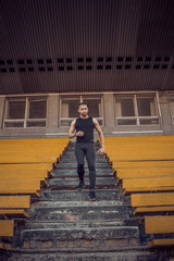 Caucasian man trains in running on the stairs. Track and field runner in sport uniform training outdoor. athlete, top view. step exercise. steps down. vertical