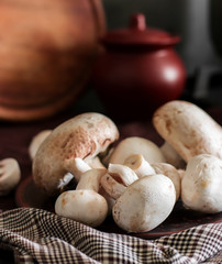 Fresh champignon mushrooms group on the table. Fresh vegetables mushrooms - the concept of healthy proper nutrition. Dark Food Photography