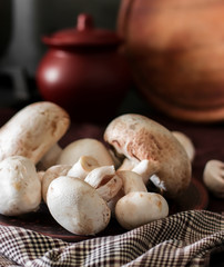 Fresh champignon mushrooms group on the table. Fresh vegetables mushrooms - the concept of healthy proper nutrition. Dark Food Photography