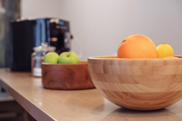 Obraz na płótnie Canvas Wooden bowls with fruit are standing on the cafe bar against a blurred background. Concept of festive atmosphere and vegetarian snacks