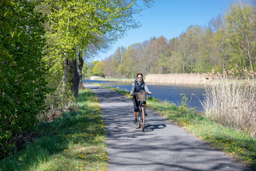 Frau auf dem Fahrrad am Vosskanal in Brandenburg