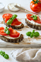 Toasted bread with tomatoes, ricotta (cream cheese), basil