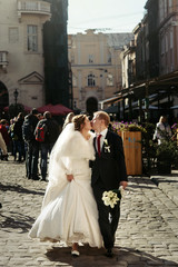happy luxury bride and stylish groom having fun emotions on the background old sunny city