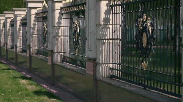 Classic fence with columns and metal bars around the park. Sunny day. Close-up
