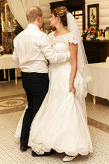 Naklejka premium happy gorgeous bride and stylish groom dancing in rich restaurant with tender feelings, romantic moment