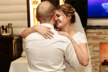 happy gorgeous bride and stylish groom dancing in rich restaurant with tender feelings, romantic moment