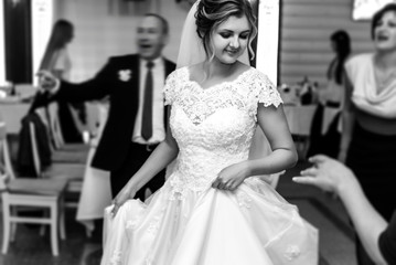 Fototapeta premium happy gorgeous bride and stylish groom dancing and having fun at luxury wedding reception