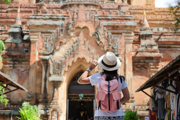 Young woman traveling backpacker with hat, Asian traveler looking Beautiful ancient temples and...