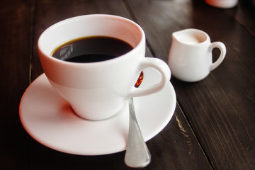 beautiful stylish stunning white cups with coffee and milk on a wooden table