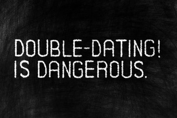 Obraz premium Double Dating is Dangerous on Grunge Chalkboard Background.