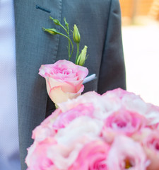 Flower in the buttonhole of his jacket the groom. Wedding bouquet in hands of the bride groom. Wedding day. Wedding decorations. Happy newlyweds.