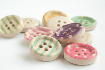 Wooden buttons with colorful stripes and colorful dots on a white background
