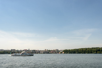 Naklejka premium luxury cruise liner sailing at sunny lake at the city, summer vacation concept