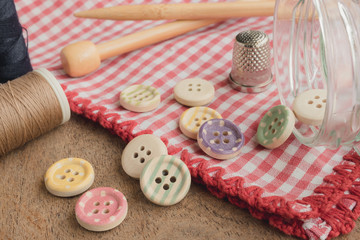 Wooden buttons with colored stripes of colors on a red and white checkered tablecloth