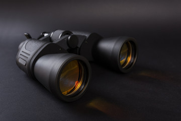 Black binoculars with orange lens
