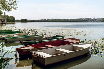 Fototapeta na wymiar amazing view at old colorful wooden boats at sunny lake at the city, summer vacation concept