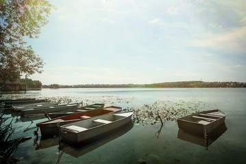 Fototapeta na wymiar amazing view at old colorful wooden boats at sunny lake at the city, summer vacation concept