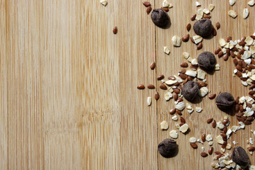 Chocolate ships, oats, seeds on wood background 