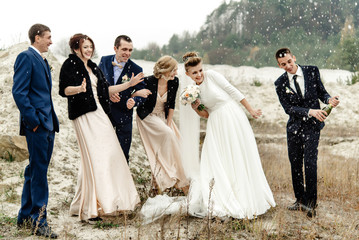 bride and groom with happy groomsmen and bridesmaids having fun and popping champagne, luxury...