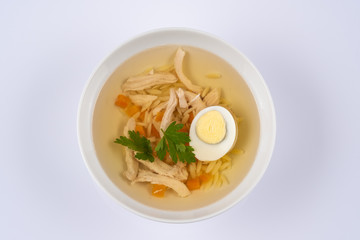 bowl on a table with chicken herbs, gg and noodles soup