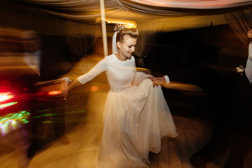gorgeous bride and stylish groom emotionally dancing, luxury wedding reception in restaurant, cool...