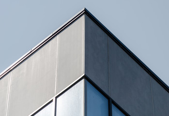 Fototapeta na wymiar corner of a gray concrete building with windows