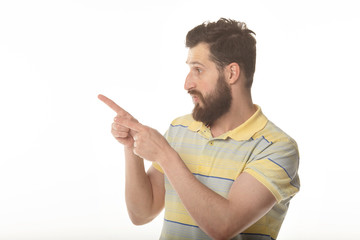 Young man in shirt pointing to the side with a finger to present a product or an idea while looking forward smiling on isolated white background 