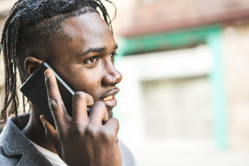 Attractive African American Guy portrait talking on mobile phone on the street