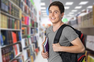 Smiling handsome boy with books on  background