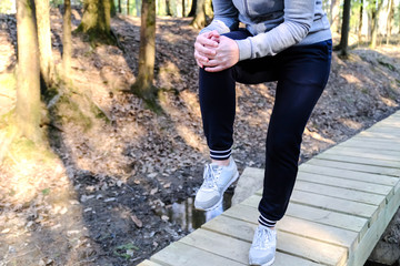 Sports injury. Woman with pain in knee while jogging.