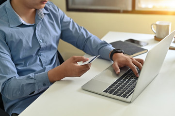 Cropped shot of man input credit card information while shopping online.