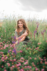 Fototapeta na wymiar beautiful girl in green dress in flower field in spring outdoors